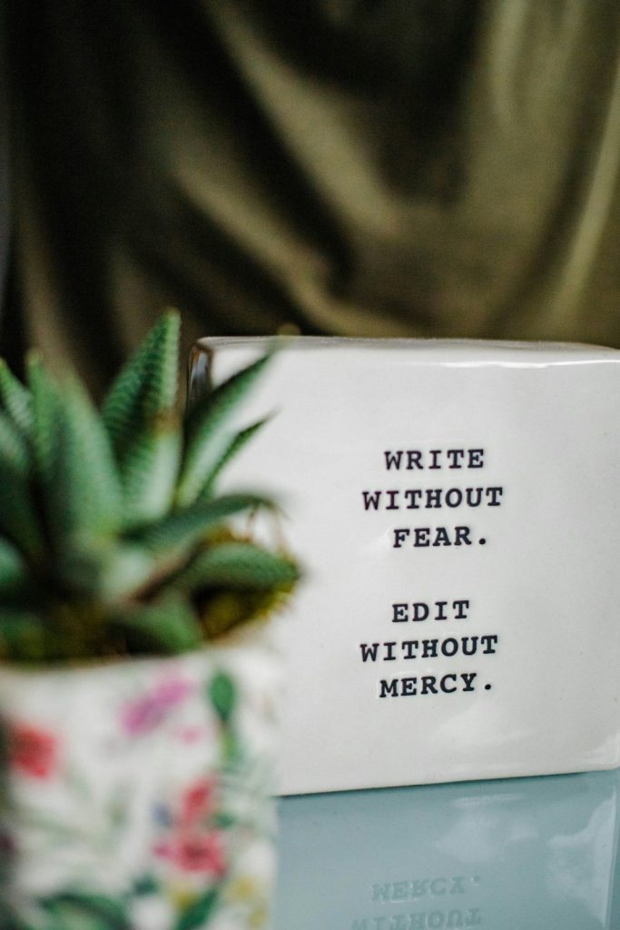 Tasse blanche avec la citation “Write without fear. Edit without mercy.” — parfaite pour illustrer les différences entre copywriting et rédaction web.